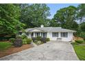 Traditional single-story house featuring a well-maintained lawn, landscaped shrubbery, and a concrete driveway at 2384 Shadowood Sw Dr, Conyers, GA 30094