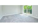 Bright bedroom features neutral carpeting, a large window, and ample natural light at 3018 Old Covington Rd, Covington, GA 30014