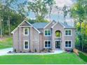 Elegant two-story brick home featuring a well-manicured lawn and beautiful landscaping at 3018 Old Covington Rd, Covington, GA 30014