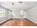 Inviting living room featuring beautiful hardwood floors, a ceiling fan, and abundant natural light from multiple windows at 155 S South Meadowcliff Cir, Carrollton, GA 30116