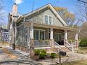 Side view of a beautiful two-story home with a covered porch, brick foundation, and manicured lawn at 958 Austin Ne Ave, Atlanta, GA 30307