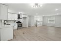 An open-concept design seamlessly integrates a modern kitchen with stainless steel appliances to the home's living space at 1277 Muirforest Dr, Stone Mountain, GA 30088