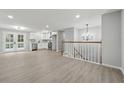 Bright living space featuring a white kitchen, hardwood floors, chandelier, and a staircase with wooden railings at 1277 Muirforest Dr, Stone Mountain, GA 30088