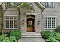 Close up of a luxurious brick home entrance featuring double doors and stone walkway at 272 Lake Forrest Ne Ln, Atlanta, GA 30342