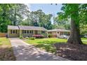 Inviting single-story home with a long driveway and lush green lawn in a tranquil setting at 2985 Westbury Dr, Decatur, GA 30033