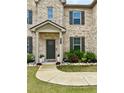 Inviting front entrance with a landscaped yard, stone border, and dark front door at 4814 Sultana Sw Way, Atlanta, GA 30331
