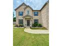Beautiful brick house with a well-maintained lawn and a stone-lined flower bed at 4814 Sultana Sw Way, Atlanta, GA 30331