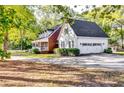 Beautiful view of this home with a long driveway, manicured lawn, a detached garage, and a lovely front porch at 965 Sundew Se Dr, Conyers, GA 30013