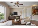 Bright living room featuring hardwood floors, view to the kitchen, sliding glass door, and modern ceiling fan at 326 Roswell Se St # 508, Marietta, GA 30060