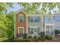 Charming two-story townhome featuring a mix of brick and siding, complemented by gray shutters and well-manicured landscaping at 9155 Nesbit Ferry Rd # 65, Alpharetta, GA 30022