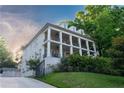 Elegant three-story home with white brick, columns, balconies, driveway, and manicured lawn at 790 Lakeview Ne Ave, Atlanta, GA 30308