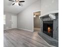 Inviting living room features a fireplace, ceiling fan, modern gray plank flooring, and open floorplan at 1353 Litchfield Ct, Snellville, GA 30078