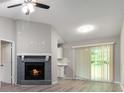 Cozy living room features a fireplace, ceiling fan, sliding glass doors, and modern gray plank flooring at 1353 Litchfield Ct, Snellville, GA 30078