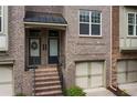 Brick townhome with covered stairway entrance and attached garages at 1973 Cobblestone Cir, Brookhaven, GA 30319
