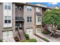 Brick townhomes with garages and stairway entrances, complemented by lush landscaping at 1973 Cobblestone Cir, Brookhaven, GA 30319