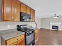 Modern kitchen featuring wood cabinets, black appliances, and an opening to the living room at 1280 Chandler Ridge Dr, Lawrenceville, GA 30045