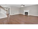 Spacious living room featuring hardwood floors, a fireplace, and an adjacent staircase at 1280 Chandler Ridge Dr, Lawrenceville, GA 30045