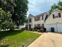 Inviting two-story home with a two car garage, and a lush green lawn at 130 Hazelhurst Dr, Covington, GA 30016