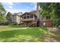 Expansive backyard featuring a screened porch, lush green lawn, and mature trees, ideal for outdoor living and entertaining at 4840 Spring Park Cir, Suwanee, GA 30024