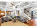 Comfortable living room featuring coffered ceilings, hardwood floors, and an open layout, perfect for relaxing and entertaining at 4840 Spring Park Cir, Suwanee, GA 30024