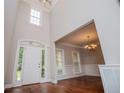 Elegant foyer with soaring ceilings, hardwood floors, and wainscoting leading to a dining room at 5995 Azalea Ridge Dr, Douglasville, GA 30135