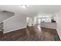 Open-concept living space with stairs, half bath, wood-look floors, and kitchen access at 310 Ashigan St, Union City, GA 30291