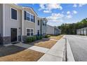 Street view of townhomes with sidewalks, landscaping, and a row of attractive facades at 310 Ashigan St, Union City, GA 30291