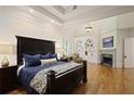 Spacious primary bedroom featuring a tray ceiling, fireplace, built-in shelves, and hardwood floors at 5119 Greythorne Ln, Marietta, GA 30068