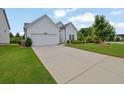 Single-story home with a two-car garage, long driveway, and professionally landscaped front yard at 5320 Coltman Dr, Cumming, GA 30028