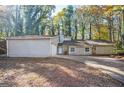 Charming one-story house with a garage, surrounded by lush trees at 5474 Post Road Pass, Stone Mountain, GA 30088