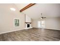 Spacious living room with vaulted ceiling, beam, fireplace, and wood-look flooring throughout at 5474 Post Road Pass, Stone Mountain, GA 30088