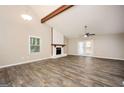 Open-concept living room features a fireplace, ceiling fan, and hardwood floors at 5474 Post Road Pass, Stone Mountain, GA 30088