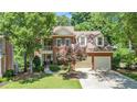 Beautiful two-story brick home with a two-car garage and lush landscaping, offering curb appeal at 1600 Heritage Trl, Roswell, GA 30075