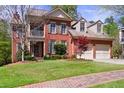 Beautiful brick two-story home with dormer windows and attached two car garage at 1600 Heritage Trl, Roswell, GA 30075