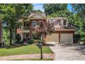Beautiful two-story brick home with well-manicured lawn, two-car garage, and lovely trees at 1600 Heritage Trl, Roswell, GA 30075