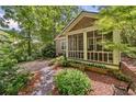 Quaint home featuring a lovely screened porch surrounded by mature trees and greenery at 4649 Dahlia Dr, Pine Lake, GA 30072