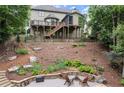 Landscaped backyard with terraced levels, stone retaining walls, a fire pit, and multi-level decks at 7059 Hunters Rdg, Woodstock, GA 30189