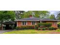 Brick home with a carport and manicured landscaping at 894 Nottingham Dr, Avondale Estates, GA 30002