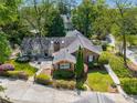 An aerial view of a brick home with a fenced backyard, mature trees, and a detached garage at 1041 Standard Ne Dr, Brookhaven, GA 30319