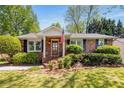 Inviting brick home with manicured landscaping, a front porch, and an American flag on display at 1041 Standard Ne Dr, Brookhaven, GA 30319