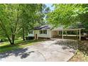 Charming single-story home with a red front door, carport, and a spacious driveway at 128 Reynolds Bridge Rd, Kingston, GA 30145