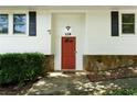 Close-up of the home's red front door, flanked by stone accents and black shutters at 128 Reynolds Bridge Rd, Kingston, GA 30145