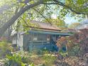 Cozy home exterior featuring a covered porch, lush greenery, and a tranquil garden setting at 23 Gould Se St, Atlanta, GA 30315