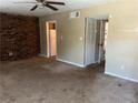 Living room featuring a brick wall, ceiling fan, and access to the kitchen at 6354 Shannon Pkwy # 13C, Union City, GA 30291