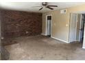 Living room featuring a brick wall, ceiling fan, and access to the kitchen at 6354 Shannon Pkwy # 13C, Union City, GA 30291