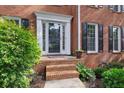 Elegant front entrance with brick steps, detailed trim, and lush landscaping providing curb appeal at 1300 Sever Woods Dr, Lawrenceville, GA 30043