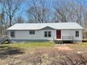 Welcoming home featuring vinyl siding, metal roof, gray trim and a cozy front porch and a small yard at 7301 Staton Se Pl, Acworth, GA 30102