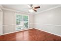 Bright dining room with hardwood floors, crown molding, and large window at 5141 Rocky Run, Stone Mountain, GA 30088