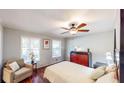 Inviting bedroom with a ceiling fan, wood floors, and comfortable seating area with large windows at 2668 Kings Way, Lawrenceville, GA 30044