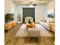 Staged living room with neutral decor, including wood floors, furniture, rug, and a ceiling fan at 19302 Waldrop Cv, Decatur, GA 30034